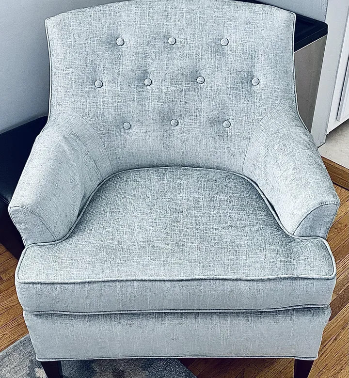 Button-tufted armchair rebuilt and recovered in pale blue-grey