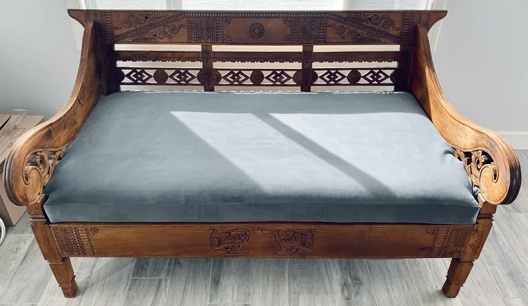Carved settee restored with a blue-grey seat cushion