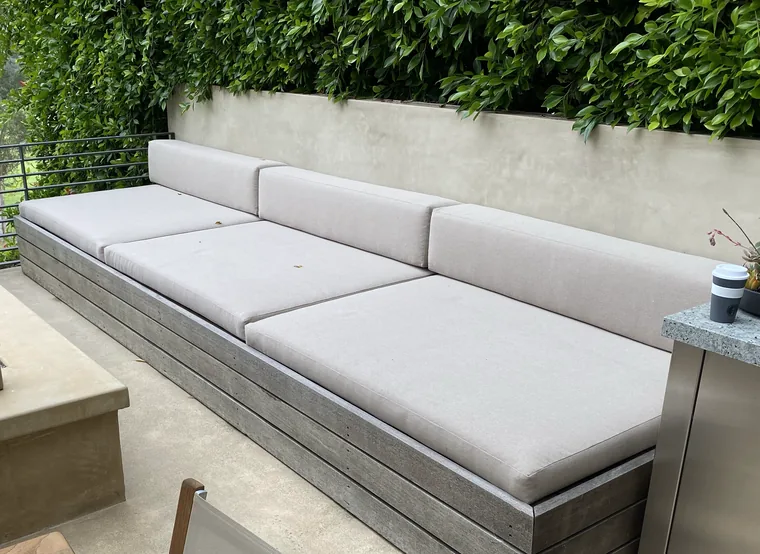 Long outdoor bench with cream weatherproof cushions