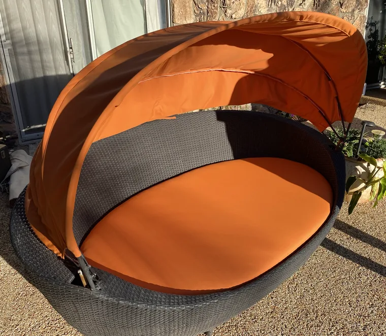 Rattan canopy daybed rebuilt with orange outdoor fabric