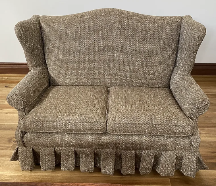 Wingback loveseat recovered in tweed with a skirt